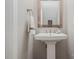 Stylish pedestal sink with a framed mirror and neutral wall color creates a clean and modern bathroom at 4124 Melrose Club Dr, Matthews, NC 28105