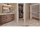 Bathroom featuring a vanity, walk-in closet, and natural stone tile at 4201 Quail Hunt Ln, Charlotte, NC 28226