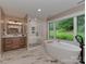 Luxurious bathroom featuring a soaking tub, glass-enclosed shower, and modern vanity at 4201 Quail Hunt Ln, Charlotte, NC 28226