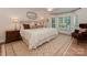 Comfortable bedroom with a decorative rug, light colored walls, and lots of light from large bay windows at 4201 Quail Hunt Ln, Charlotte, NC 28226