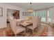 Bright dining room featuring a rustic table, elegant seating, chandelier, and scenic backyard views at 4201 Quail Hunt Ln, Charlotte, NC 28226