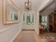 Bright foyer with hardwood floors, paneled walls, a decorative mirror and modern light fixture at 4201 Quail Hunt Ln, Charlotte, NC 28226