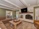 Inviting living room featuring a brick fireplace, wood beams, and comfortable seating at 4201 Quail Hunt Ln, Charlotte, NC 28226