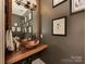 Stylish powder room features a copper vessel sink, wood countertop, and modern fixtures at 4201 Quail Hunt Ln, Charlotte, NC 28226