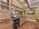 Elegant wet bar featuring custom cabinets, granite countertop, wine fridge, and mirror backsplash at 4201 Quail Hunt Ln, Charlotte, NC 28226