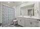 Bright bathroom with double sink vanity, floral shower curtain, and tiled floor at 449 Misty Law Ln, Clover, SC 29710