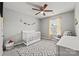 Bedroom features a gray walls, crib, rocking chair, and a window with yellow accents at 449 Misty Law Ln, Clover, SC 29710
