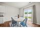 Cozy dining area with a white table, blue chairs, and natural light from a sliding door at 449 Misty Law Ln, Clover, SC 29710