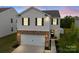 Inviting two-story home featuring a brick facade, attached garage, and manicured landscaping at 449 Misty Law Ln, Clover, SC 29710