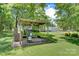 Cozy backyard barbecue area with a grill, dining table, and lush greenery at 4648 Rifle Range Rd, Conover, NC 28613