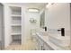 Bright bathroom with double vanity, tiled floors, and storage shelves at 4648 Rifle Range Rd, Conover, NC 28613