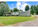 Lawn view of this home on a large lot with an attached carport, mature trees and landscaping at 4648 Rifle Range Rd, Conover, NC 28613