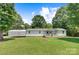 Charming single story home with white siding, covered porch, large yard, and canopy in a lush green setting at 4648 Rifle Range Rd, Conover, NC 28613