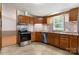 Kitchen showcasing stainless steel appliances, mosaic backsplash, wooden cabinets and tile floors at 4648 Rifle Range Rd, Conover, NC 28613