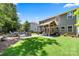 Spacious backyard featuring lush green grass, covered patio, and inviting fire pit seating area at 5088 Watersail Way, Clover, SC 29710