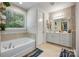 Bright bathroom featuring a soaking tub, double sink vanity, and a window at 5088 Watersail Way, Clover, SC 29710