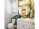 Stylish half bathroom with a unique design, featuring a modern vanity, wallpaper and a round mirror at 5088 Watersail Way, Clover, SC 29710