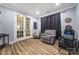 Relaxing bonus room with hardwood floors, comfortable seating, and dark curtains at 5088 Watersail Way, Clover, SC 29710