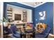 Stylish dining area with a glass table, blue chairs, and built-in bar shelving at 5088 Watersail Way, Clover, SC 29710