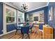 Cozy dining room featuring a glass-top table, blue accent wall, and elegant lighting fixture at 5088 Watersail Way, Clover, SC 29710