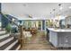 Bright and open living room connected to the kitchen with hardwood floors and pendant lighting at 5088 Watersail Way, Clover, SC 29710