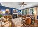 Elegant living room with fireplace, hardwood floors, stylish furnishings, and decor illuminated by natural light from large windows at 5088 Watersail Way, Clover, SC 29710