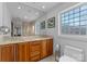 Bright bathroom boasts a glass shower, wood cabinets, double sink and neutral tile at 5153 Glenwood St, Sherrills Ford, NC 28673