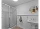 Clean bathroom featuring a glass-enclosed shower, pedestal sink with wainscotting, and tile flooring at 5153 Glenwood St, Sherrills Ford, NC 28673