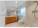 Bright bathroom boasts a glass shower, wood cabinets, double sink and neutral tile at 5153 Glenwood St, Sherrills Ford, NC 28673