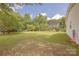 Expansive backyard with lush green grass and mature trees, ideal for outdoor activities at 5840 Potter Rd, Matthews, NC 28104