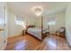 Comfortable bedroom with a four-poster bed, side table and chair, featuring hardwood floors at 5840 Potter Rd, Matthews, NC 28104