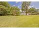 Well-manicured front yard with lush green grass and mature trees, enhancing curb appeal at 5840 Potter Rd, Matthews, NC 28104
