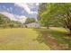 Spacious yard with lush green grass and mature trees, offering privacy and serenity at 5840 Potter Rd, Matthews, NC 28104
