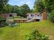 Backyard featuring a fire pit with Adirondack chairs, detached garage, and lush landscaping at 607 Coulwood Dr, Charlotte, NC 28214