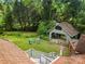 Aerial view of backyard featuring a fire pit with Adirondack chairs, detached garage and lush landscaping at 607 Coulwood Dr, Charlotte, NC 28214