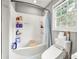 Bright bathroom featuring a shower-tub combination and practical storage at 607 Coulwood Dr, Charlotte, NC 28214