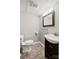 Bathroom with a toilet, vanity with sink, and mirror with a modern light fixture at 607 Coulwood Dr, Charlotte, NC 28214