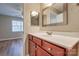 Bright bathroom featuring a white countertop, a mirror, and a door leading to a spacious bedroom at 623 Olmsted Park Pl # D, Charlotte, NC 28203