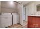 Functional laundry room with washer and dryer, alongside a dark wood vanity and storage shelving at 623 Olmsted Park Pl # D, Charlotte, NC 28203
