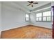 Spacious bedroom with hardwood floors, tray ceiling, and windows with white shutters at 750 Waterscape Ct, Rock Hill, SC 29730
