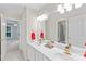Bright bathroom showcasing double sinks with gold hardware and a large mirror over a white vanity at 763 Evans Manor Dr, Weddington, NC 28104