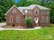 Beautiful two-story brick home with meticulously maintained landscaping and a welcoming front entrance at 763 Evans Manor Dr, Weddington, NC 28104