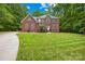 Spacious two-story brick home on a sprawling green lawn, surrounded by mature trees, offering a serene setting at 763 Evans Manor Dr, Weddington, NC 28104