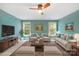 Bright living room showcasing a large rug, teal walls, neutral furniture and several sunny windows at 763 Evans Manor Dr, Weddington, NC 28104