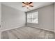 Well-lit bedroom featuring neutral walls, cozy carpeting, a ceiling fan, and a large window for ample natural light at 841 Lacebark Dr, Rock Hill, SC 29732