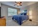 Comfortable bedroom with a plush blue bed, ceiling fan, and natural light from the window, creating a peaceful retreat at 841 Lacebark Dr, Rock Hill, SC 29732