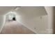 Spacious, carpeted attic area with a window, offering potential for versatile use and ample storage at 8506 Graham Rd, Denver, NC 28037