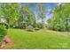 Spacious backyard featuring mature trees and lush green lawn at 8506 Graham Rd, Denver, NC 28037