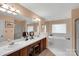 Bright bathroom with dual sinks, vanity, walk-in shower and separate soaking tub at 8506 Graham Rd, Denver, NC 28037