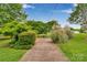 Well-manicured front yard with a stone pathway surrounded by lush greenery and landscaping at 8506 Graham Rd, Denver, NC 28037